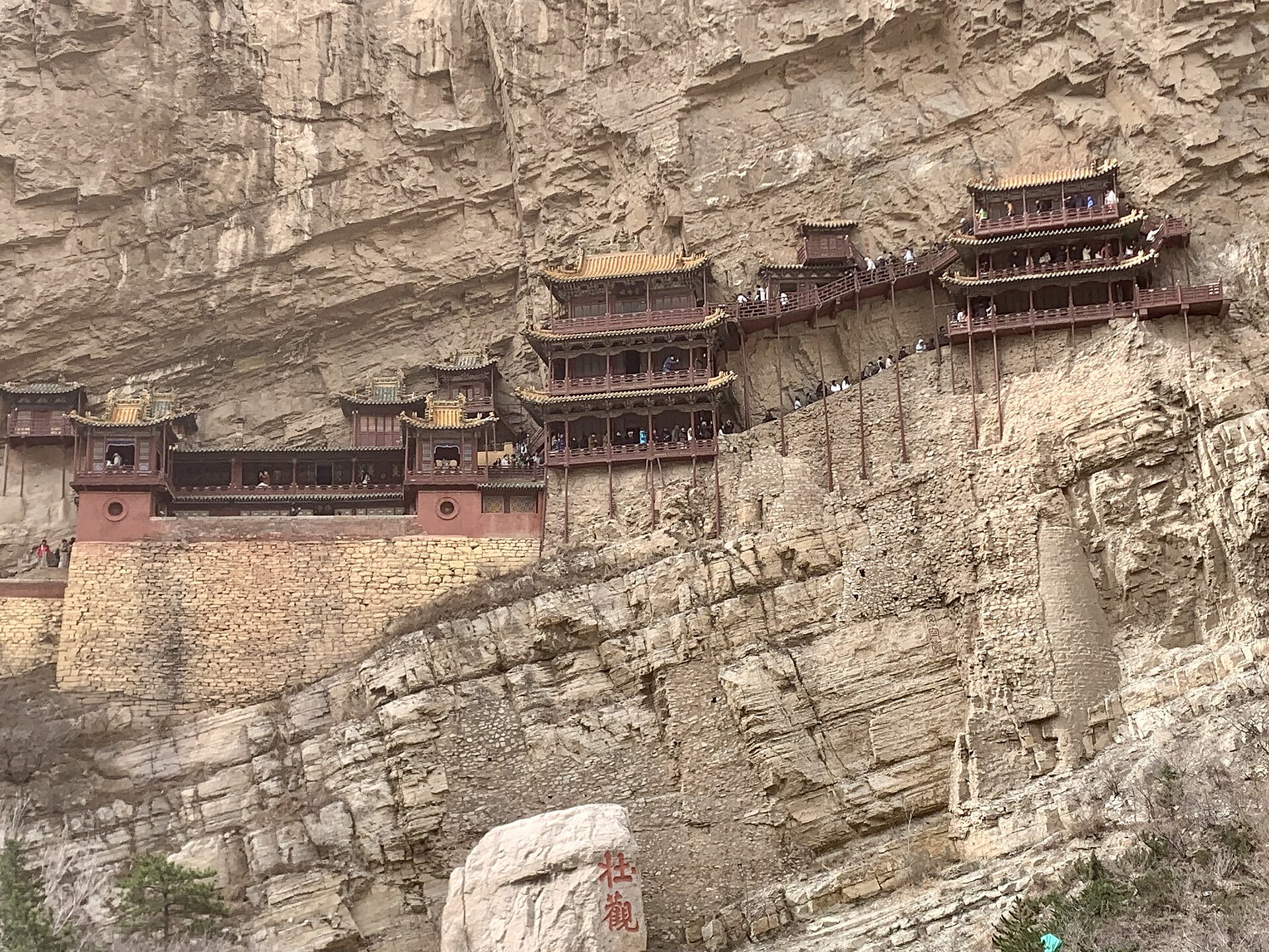悬空寺贴在恒山崖壁上，木构殿阁由横梁插入岩体支撑